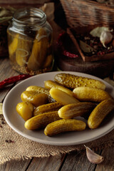 Homemade canned gherkins on a rustic wooden background.