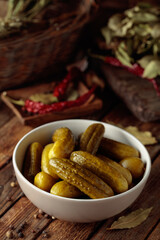 Homemade canned gherkins on a rustic wooden background.