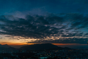 Bright sunset over the silhouette mountains at evening time.