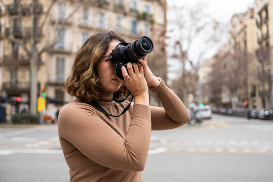 Woman photographing city scene with DSLR camera
