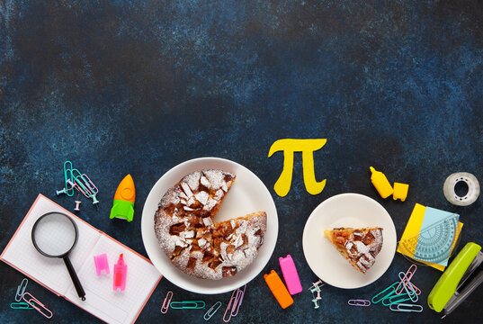 World Pi day. Baked apple pie with Pi Symbol and stationery, dark blue background.   March 14th 3.14. Mathematical constant.