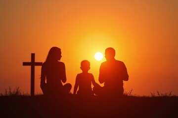 Fototapeta premium Asian Family Silhouette and Cross During Sunset: A Symbolic Moment of Prayer and Unity
