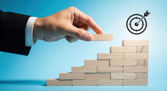 Hand adding wooden block to staircase showing steady business growth progress and long term success strategy