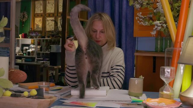 Woman learning watercolor painting in creative workshop, dipping brush into palette and practicing color mixing, cozy artist studio, creative hobby, self education, artistic lifestyle concept