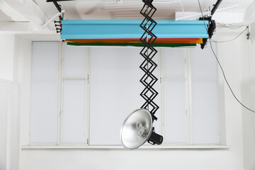 Professional lighting equipment hanging from ceiling in photo studio
