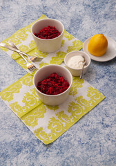 Salad of Fresh Raw Beetroot with Grated Raw Carrot, Apple and Orange on Kitchen Table.