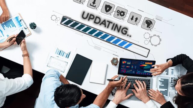 A group of professionals collaborate on a digital project in a modern office. They analyze data on a laptop, discussing updates and visual graphics, showcasing teamwork and productivity. Raster