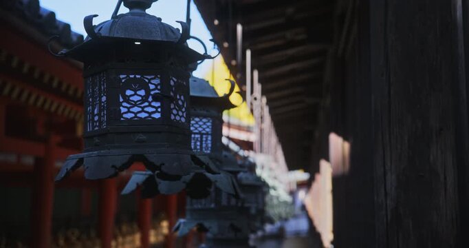 Metal, old Japanese lanterns hanging from roof - silhouette, steady cam shot