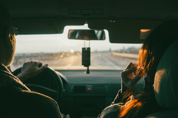 View from the back seat of the car at the couple and the highway