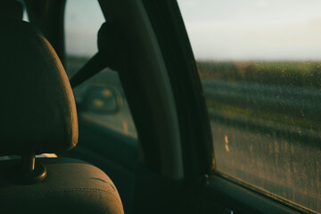 The view from the back seat of the car through the dirty window