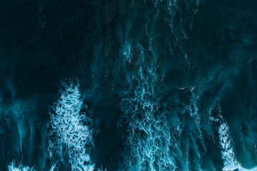 Texture of big power dark ocean waves with white wash. Aerial top view footage of fabulous sea tide on a stormy day. Drone view breaking surf with foam in Atlantic ocean