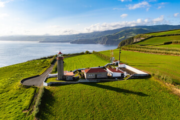 Lighthouse on cape Cintrao with Cliffs and Green Fields and Atlantic Ocean. Azores, Sao Miguel Island, Aerial View