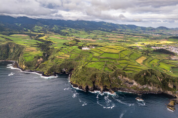 Green rural countryside shaped by volcanic landforms along Atlantic Ocean coast, Sao Miguel, Azores