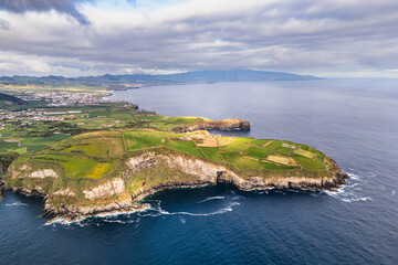 Green farmland terraces on coastal cliffs Atlantic Ocean, volcanic Azores Islands. Aerial view