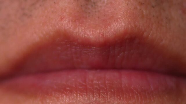 Extreme hyper-detailed macro close-up of closed neutral human lips. The shot captures every fine natural crease and texture of the lip surface, the surrounding skin, visible pores, and the dark shadow
