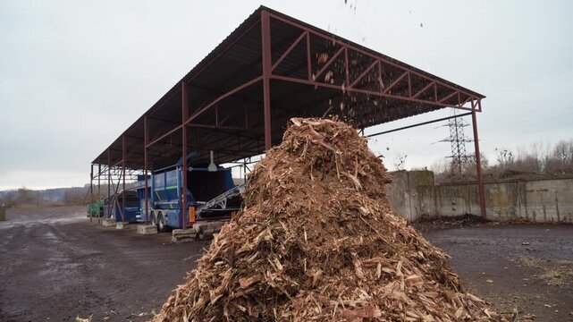 A wood chipper shreds wood into one pile. Branches and wood received at the composting station are crushed on a crusher to a fine fraction.