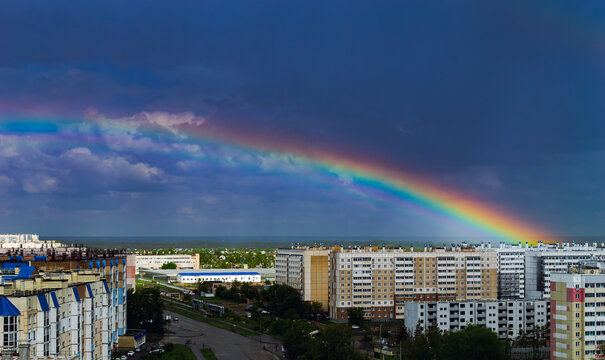 Fantastic beautiful rainbow over city buildings after rain