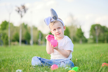 Smiling Boy Celebrating Easter Outdoors with Egg Hunt Basket