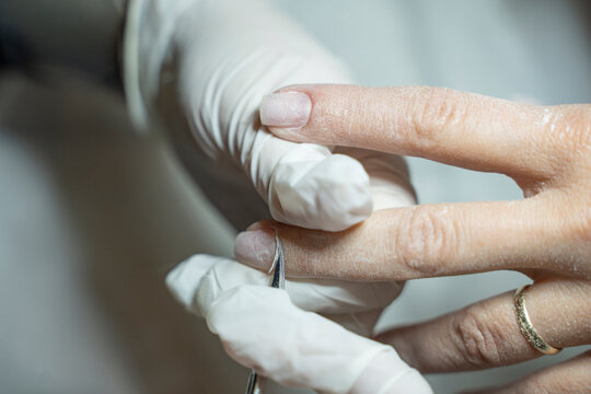 In a beauty salon, a manicurist is trimming a client's cuticles (Stock Photo).
