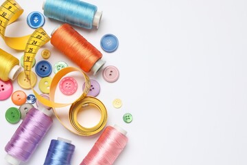 Flat lay composition with sewing supplies on white background. Space for text