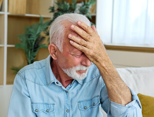 Portrait of a serious sad mature old man at home
