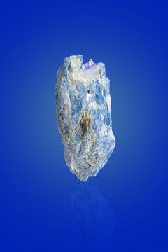A kyanite crystal on a blue background.