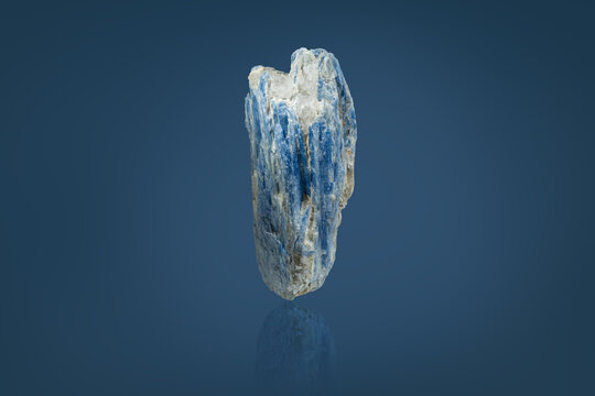 A kyanite crystal on a blue background.