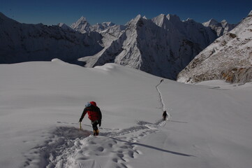 Single climber crossing vast snow field in the Himalayan mountains of Nepal.