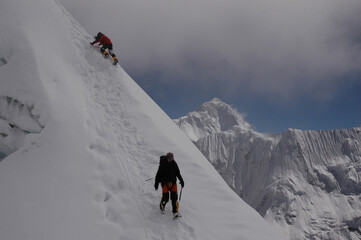 Mountaineers ascending a steep snowy ridge near Island Peak in the Himalayas, Nepal.