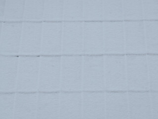 Fototapeta premium A snow‑covered sheet‑metal roof with ridges.