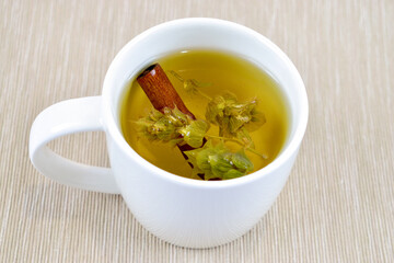 Sage herbal tea with cinnamon stick in white cup