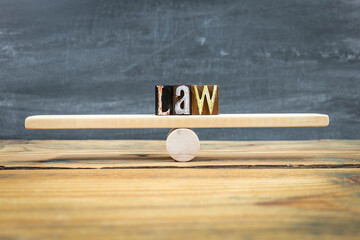 LAW Balance Concept Shown By Letter Blocks On Wooden Seesaw