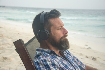 Remote Worker Using Laptop on Tropical Beach with Headphones