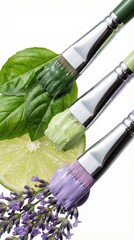 Colorful paintbrushes with green, lavender, and lime hues on fresh leaves