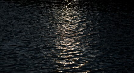 Water surface illuminated by light reflections dark tones abstract background