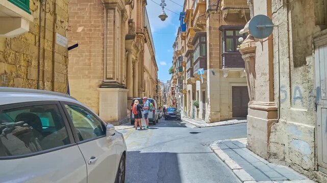 Timelapse walk along the narrow hilly St Paul street in Valletta, Malta