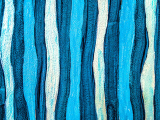 Abstract blue acrylic painting texture with hand drawn vertical wavy lines and brushstrokes on canvas background