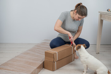 Fototapeta premium A Caucasian woman unpacks a box of furniture.