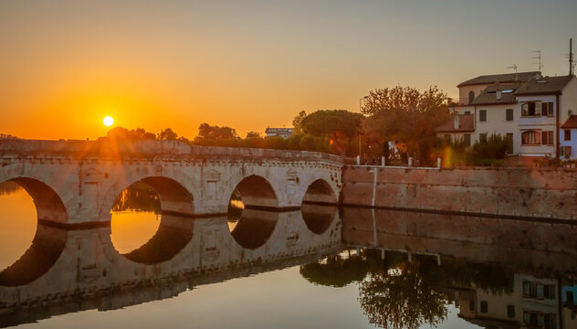 Famous Roman Bridge of Tiberius or Ponte di Tiberio in  historic center of Rimini, Italy at sunset