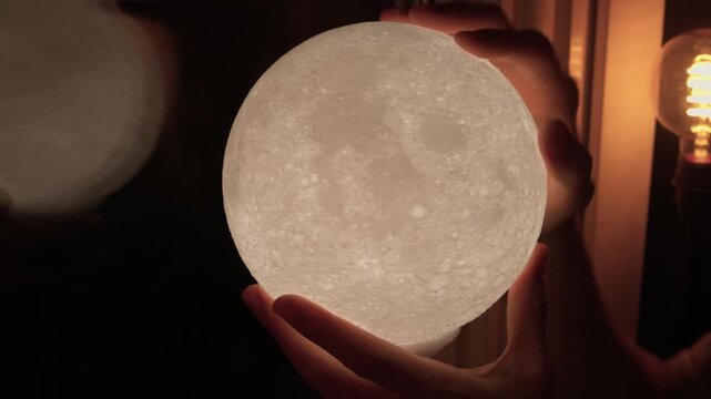 Moon lamp ambiance. Soft illuminated hands with textured surface at bedtime. Relaxing home environment highlighted by gentle moonlight illuminating fingertips and surroundings