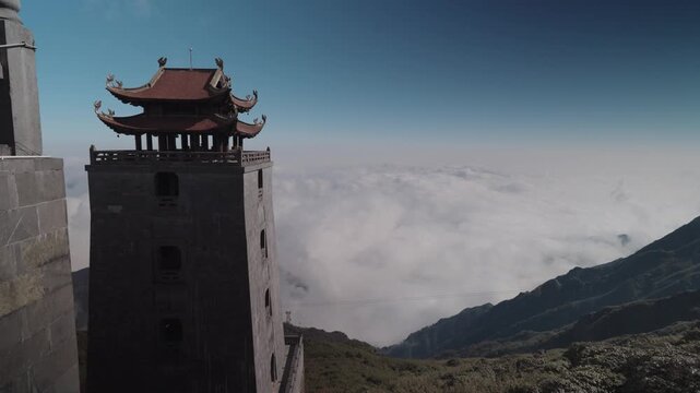 Temple architecture at the Fansipan summit in Sapa, Vietnam, featuring traditional roofs and stone structures set against clear blue sky and high-altitude mountain atmosphere.