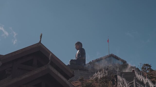 Large Buddha statue at Fansipan Mountain in Sapa, Vietnam, captured against blue sky and clouds, symbolizing spirituality, peace, and cultural heritage at Vietnam&rsquo;s highest peak.