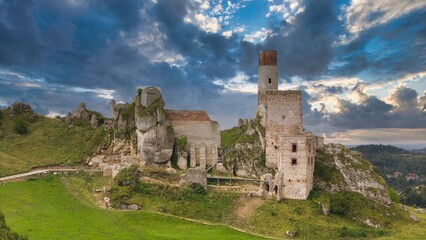 Castle ruins in Olsztyn near Częstochowa captured in golden hour light, aerial drone view over limestone rocks and historic fortress in Poland © Konrad Kerker