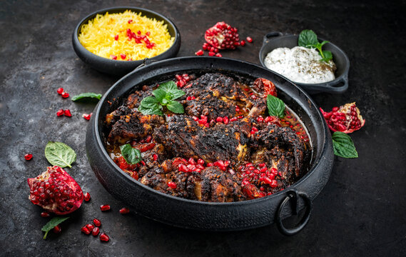 Traditional authentic persian khoresh fesenjan - chicken stew with walnut and pomegranate sauce, saffron basmati rice and mast o khiar - mint yogurt dip