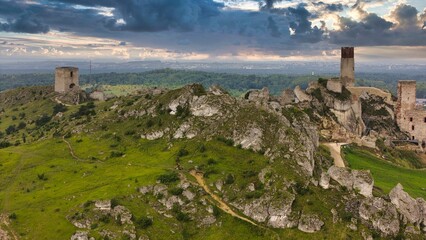 Castle ruins in Olsztyn near Częstochowa captured in golden hour light, aerial drone view over limestone rocks and historic fortress in Poland © Konrad Kerker