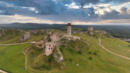 Castle ruins in Olsztyn near Częstochowa captured in golden hour light, aerial drone view over limestone rocks and historic fortress in Poland © Konrad Kerker