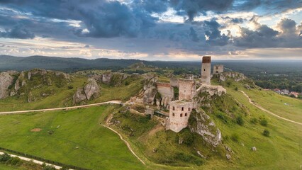 Castle ruins in Olsztyn near Częstochowa captured in golden hour light, aerial drone view over limestone rocks and historic fortress in Poland © Konrad Kerker