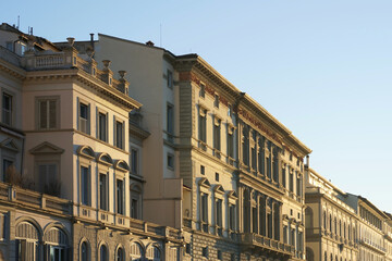 Obraz premium Side view facades of buildings surrounding the Arno River in Florence, Italy, specifically near the famous Ponte Vecchio.