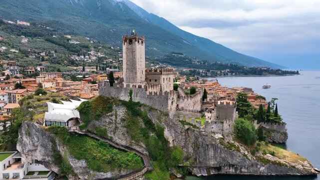 Castello Scaligero di Malcesine, a striking medieval fortress perched on a rocky promontory overlooking Lake Garda in northern Italy. 
