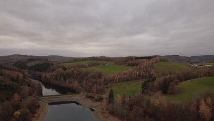 Obraz premium Autumn Lake Aerial View with Soft Light and Rolling Landscape